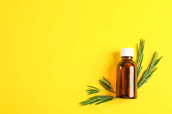 Flat lay composition with rosemary oil and leaves on yellow back — Stock Photo, Image