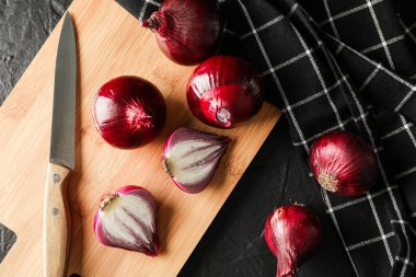 Siyah bac üzerinde kırmızı soğan, kesme tahtası ve bıçak ile Kompozisyon