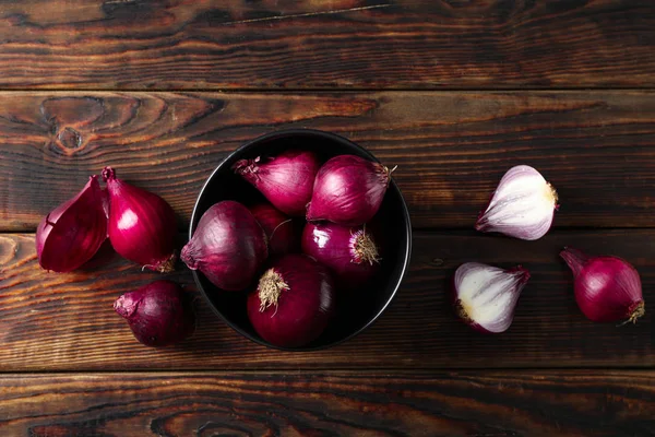 Platte lay compositie met rode ui op houten achtergrond — Stockfoto