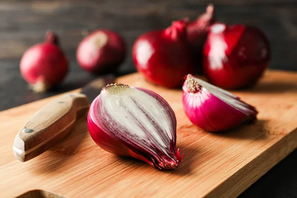 Samenstelling met rode ui, snijplank en mes op houten ta — Stockfoto