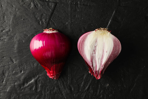 Flat lay composition with red onion on black background