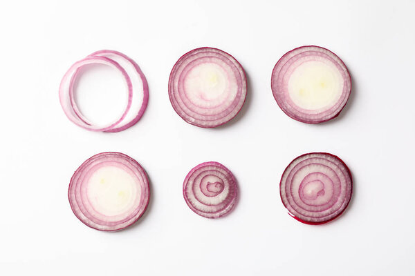 Flat lay composition with red onion rings on white background