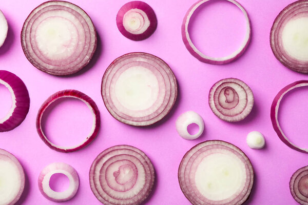 Flat lay composition with red onion rings on color background