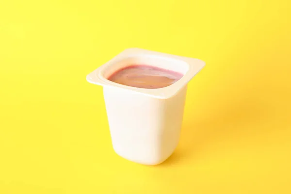 Műanyag pohár joghurtos színes háttérrel, hely a szöveghez — Stock Fotó