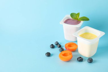 Renk arka planda yoğurt ve meyve ile Plastik bardak, uzay f