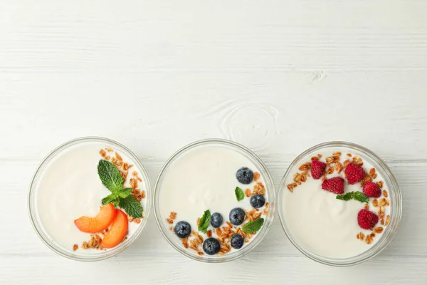 Flat lay composition with yogurt desserts and ingredients on whi — Stock Photo, Image