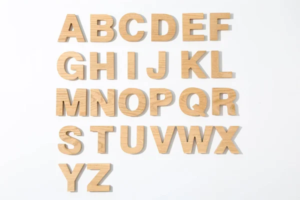 Holzbuchstaben des englischen Alphabets auf weißem Hintergrund, Ansicht von oben — Stockfoto