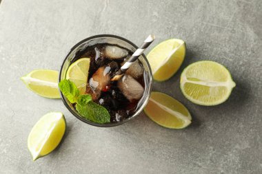 Gri masada soğuk kola ve narenciye ile gözlük, üst görünümü