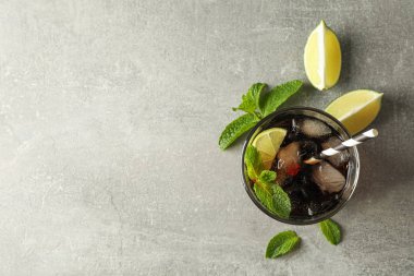 Gri masada soğuk kola ve narenciye ile gözlük, üst görünümü