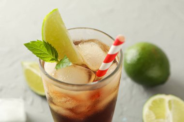 Gri çimento arka plan üzerinde soğuk kola ve narenciye ile Cam, boşluk