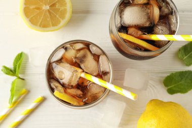 Beyaz ahşap arka planda soğuk kola ve narenciye ile Gözlük,