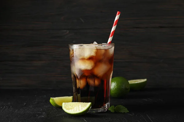 Glas koude Cola en limosen op zwarte cement achtergrond — Stockfoto