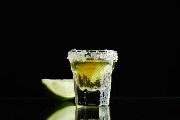 Tequila avec citron vert et sel de mer sur fond noir — Photo