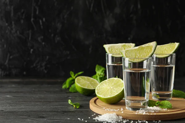 Tequila tiros com fatias de limão, sal e hortelã em backgrou de madeira — Fotografia de Stock
