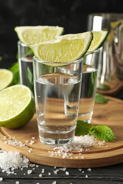 Tequila shots avec tranches de lime, sel et menthe sur backgrou en bois — Photo