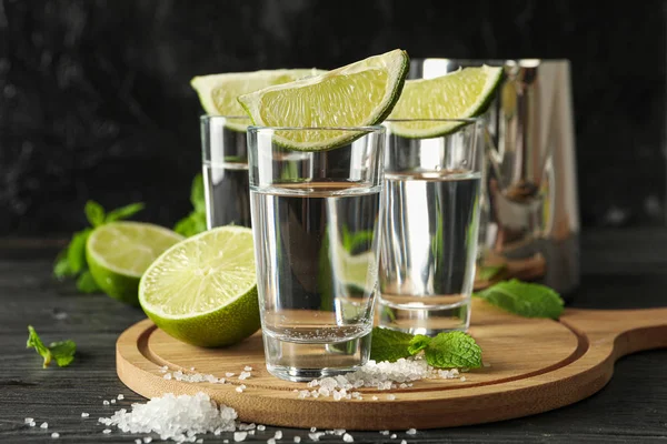 Tequila shots avec tranches de lime, sel et menthe sur backgrou en bois — Photo