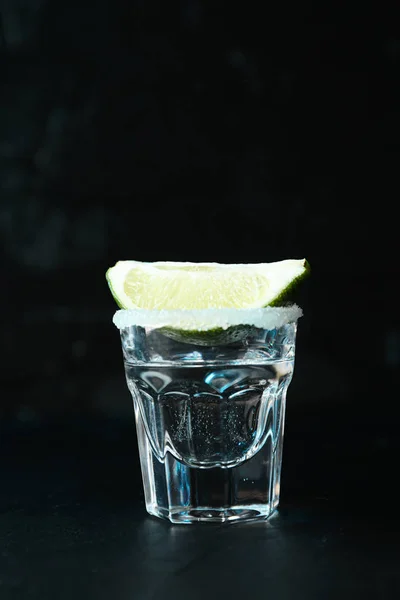 Tequila Shot med lime och salt mot svart bakgrund med bl — Stockfoto