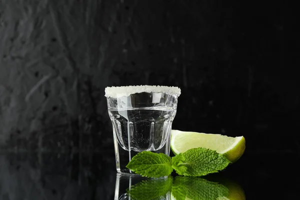 Tequila shot with lime, salt and mint against black background — Stock Photo, Image