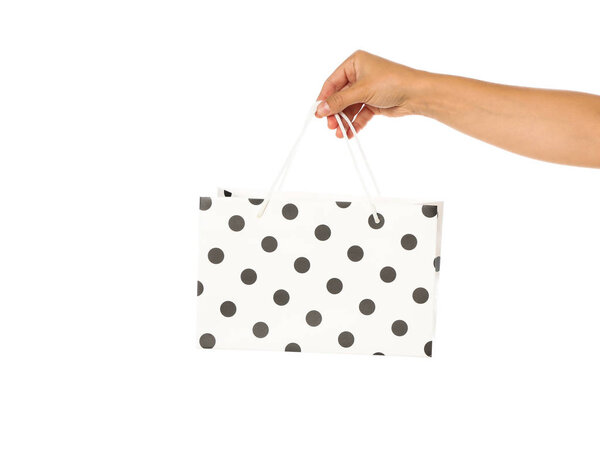 Женская рука держать цветной бумажный пакет изолированы на белом фоне
