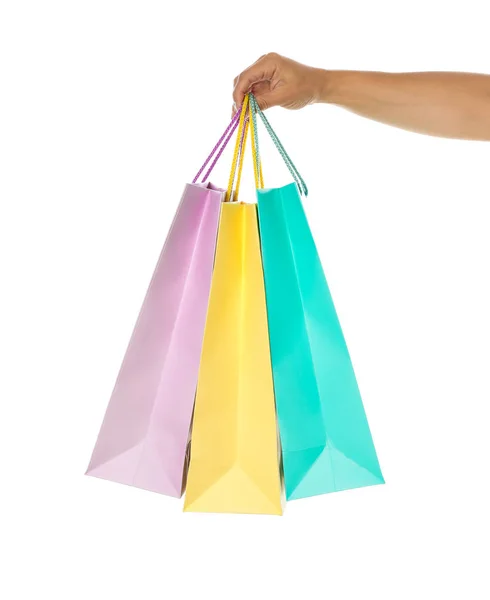 Mão feminina segurar sacos de papel de cor isolado no fundo branco — Fotografia de Stock