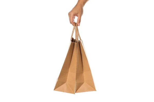 Mão feminina segurar sacos de papel isolado no fundo branco — Fotografia de Stock