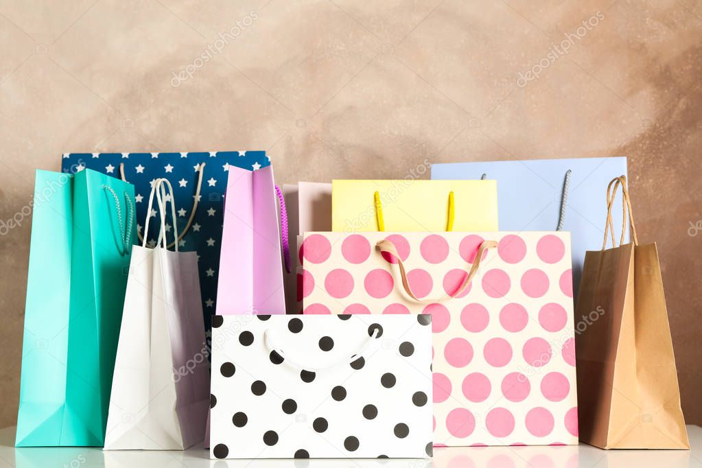 Present bags on white table against brown background, copy space