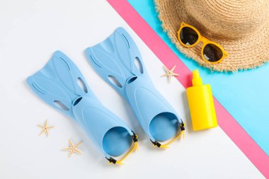 Flippers, güneş gözlüğü, hasır şapka, denizyıldızları ve col üzerinde güneş kremi