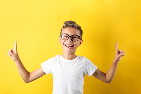 Garçon heureux dans des lunettes sur fond jaune, espace pour le texte — Photo