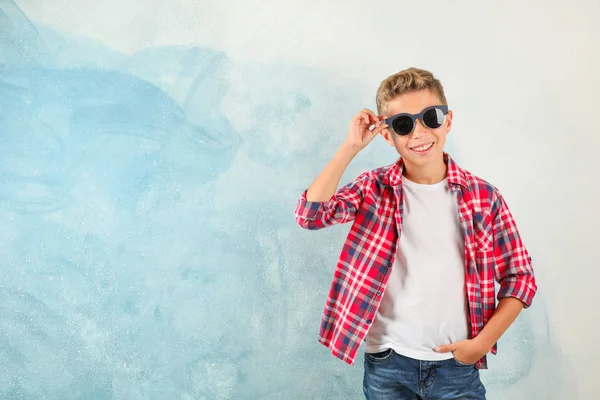 Крутой мальчик в солнечных очках на цветном фоне, место для te — стоковое фото