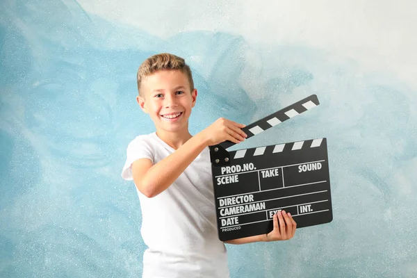 Boy with clapperboard against color background, space for text — Stock Photo, Image