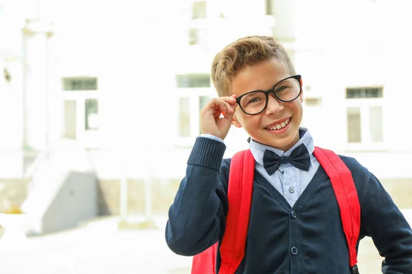 Boy with backpack against school building, space for text — Stock Photo, Image