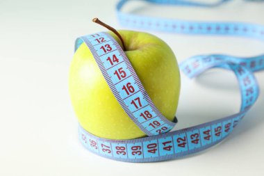 Beyaz arka planda ölçme bandı ile Apple, yakın çekim