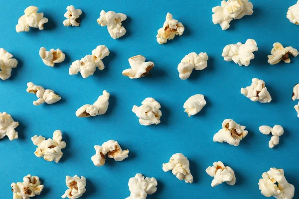 Flache Liegekomposition mit Popcorn auf blauem Hintergrund, Nahaufnahme — Stockfoto