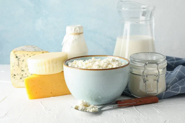 Různé mléčné výrobky na bílém stole proti modrému pozadí — Stock fotografie