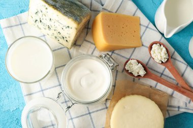 Mavi zemin üzerinde taze süt ürünleri ve mutfak havlusu
