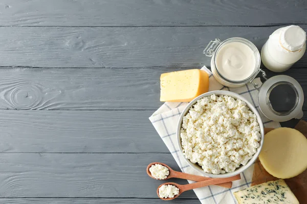 Flat lay. Different dairy products on grey wooden background, co — Stock Photo, Image