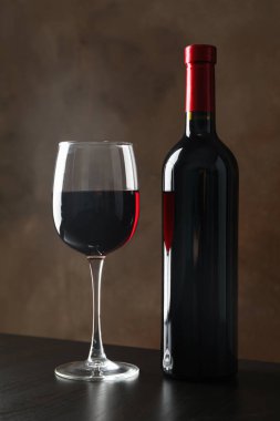 Şişe ve kahverengi arka plan karşı şarap ile cam, kopya alanı