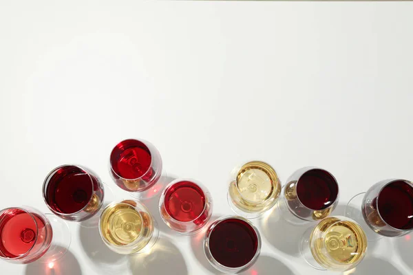 Flache Lagekomposition. Gläser mit unterschiedlichem Wein auf weißem Hintergrund, Draufsicht — Stockfoto