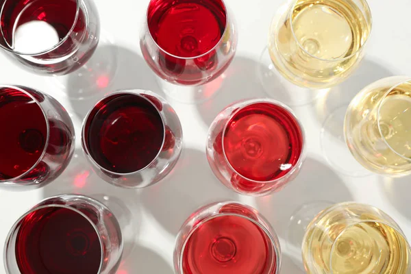 Gläser mit unterschiedlichem Wein auf weißem Hintergrund, Nahaufnahme und Draufsicht — Stockfoto