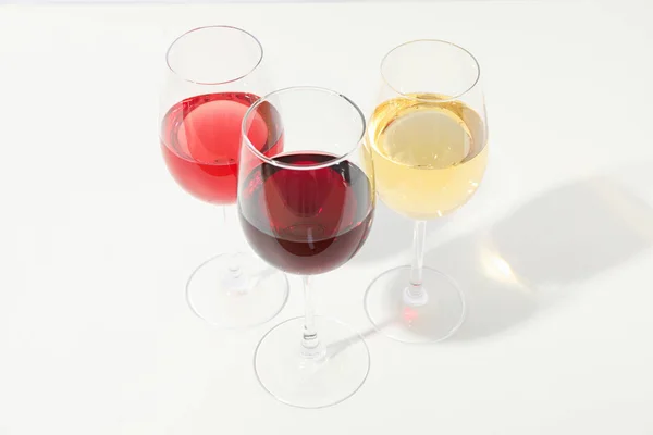 Gläser mit unterschiedlichem Wein auf weißem Hintergrund, Kopierraum — Stockfoto
