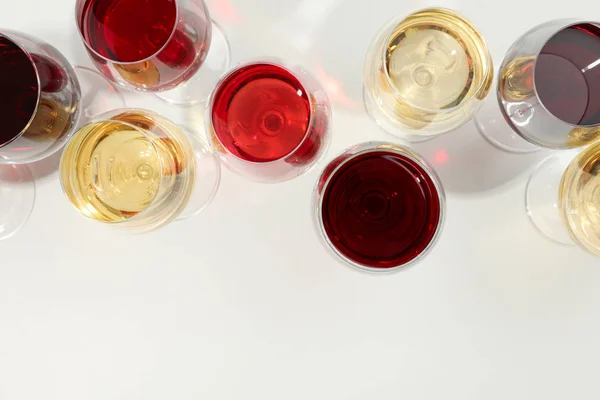 Flache Lagekomposition. Gläser mit unterschiedlichem Wein auf weißem Hintergrund, Draufsicht — Stockfoto