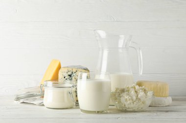 Beyaz ahşap arka plan üzerinde farklı süt ürünleri, kopyalama alanı