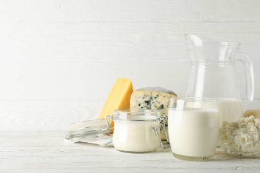 Beyaz ahşap arka plan üzerinde farklı süt ürünleri, kopyalama alanı