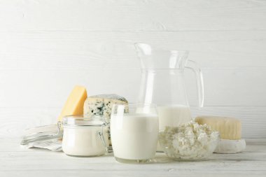 Beyaz ahşap arka plan üzerinde farklı süt ürünleri, kopyalama alanı