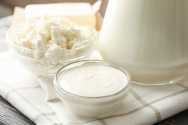 Ahşap arka planda taze süt ürünleri ve havlu, yakın