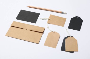 Zarf, etiketler ve beyaz arka plan üzerinde kalem, mockup