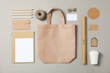 Mockup. Kurumsal kırtasiye, gri bac üzerinde çanta ve kağıt bardak