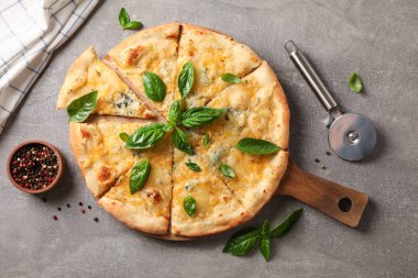 Fesleğen, kesici ve gri arka plan üzerinde baharat ile Peynir pizza, t