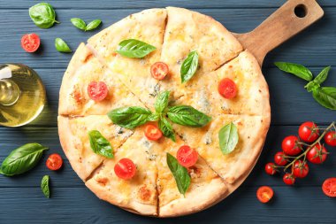 Ahşap arka plan üzerinde peynir pizza, domates ve zeytinyağı, üst v