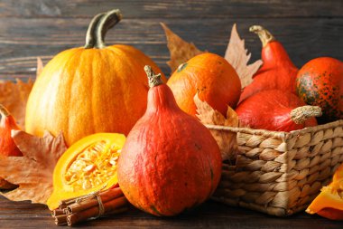 Ahşap arka planda saman sepetinde kabaklar, yakın